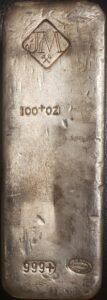 Front of Johnson Matthey 100 oz poured silver bar, stamped with JM diamond logo, 100+ oz and 999+