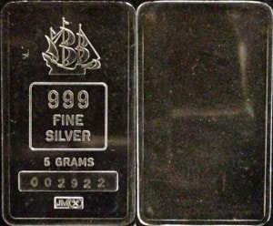 Front and back of Johnson Matthey 5 gram "Shipwreck silver" bar. Front depicts a Spanish galleon, stamped 999 Fine Silver with serial number and JM logo. Back blank.